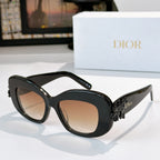 Dior sunglasses with black frames, tinted lenses, and sculpted floral detail at temples