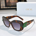 Dior sunglasses with tortoiseshell frames, dark lenses, and green floral temple detail