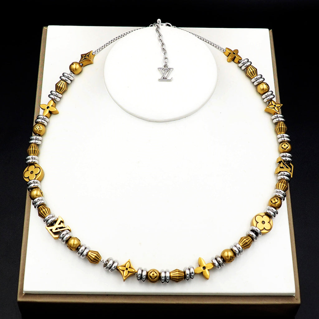Louis Vuitton beaded necklace with gold and silver charms on necklace box