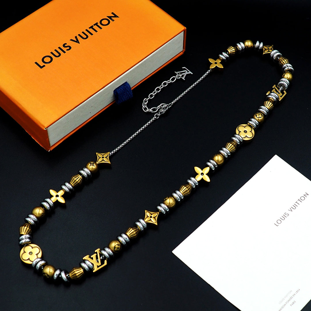 Louis Vuitton beaded necklace with gold and silver charms, laid on card