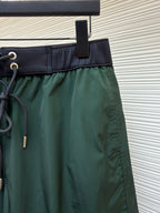 Green shorts with drawstring cord and zipperless front, dark waistband trim