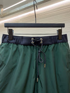Close-up of green drawstring shorts waistband with metal eyelets and cord ties