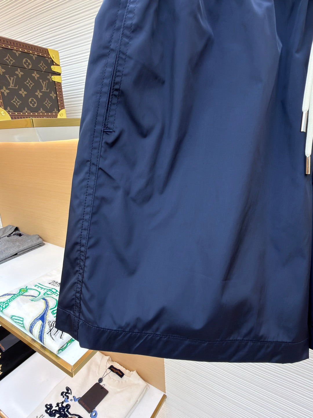 Moncler navy shorts with visible fabric texture, side seam, and pocket edge