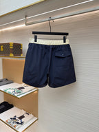 Moncler navy shorts with cream waistband, side patch pocket, and drawstring ties