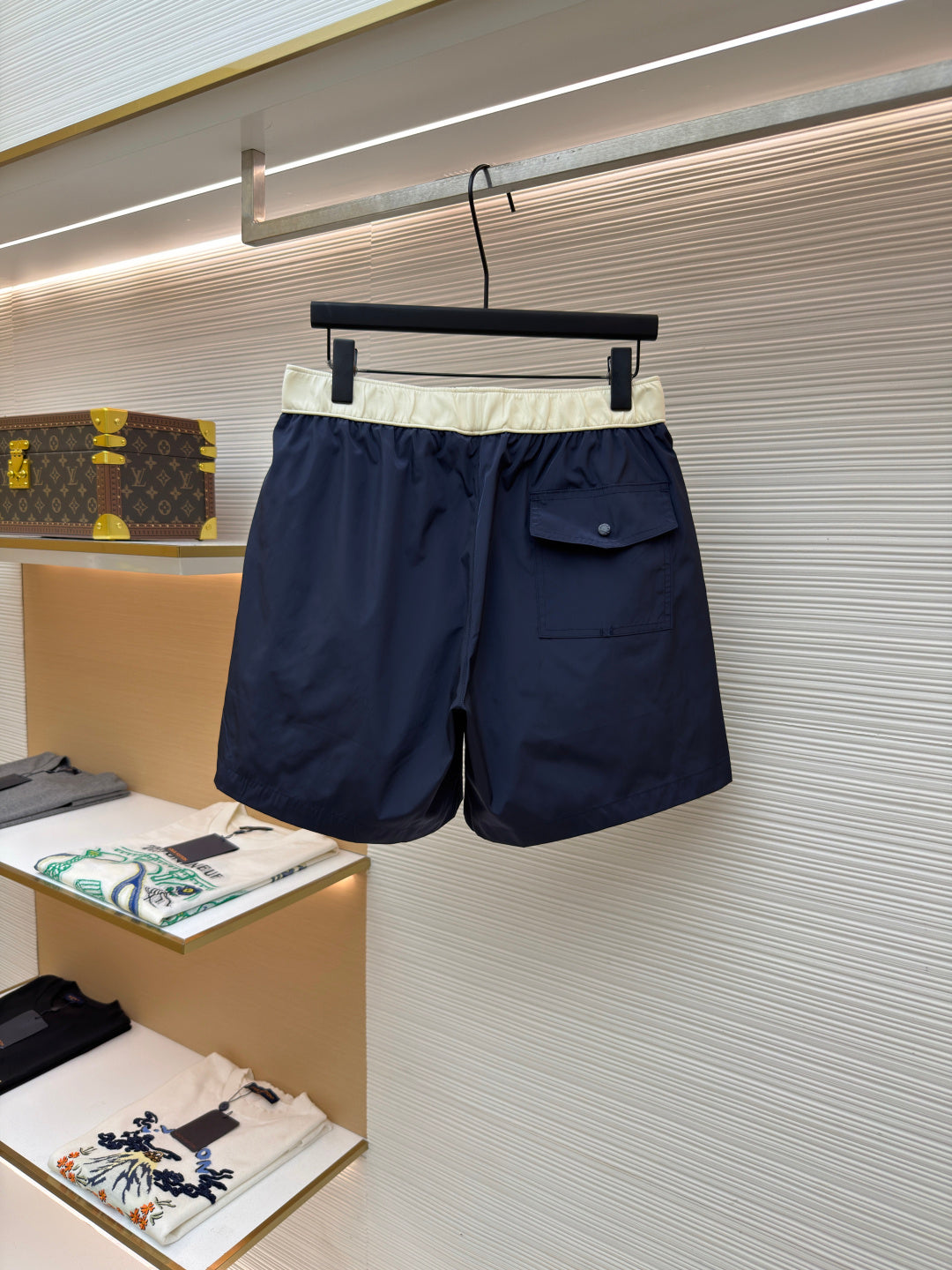 Moncler navy shorts with cream waistband, side patch pocket, and drawstring ties