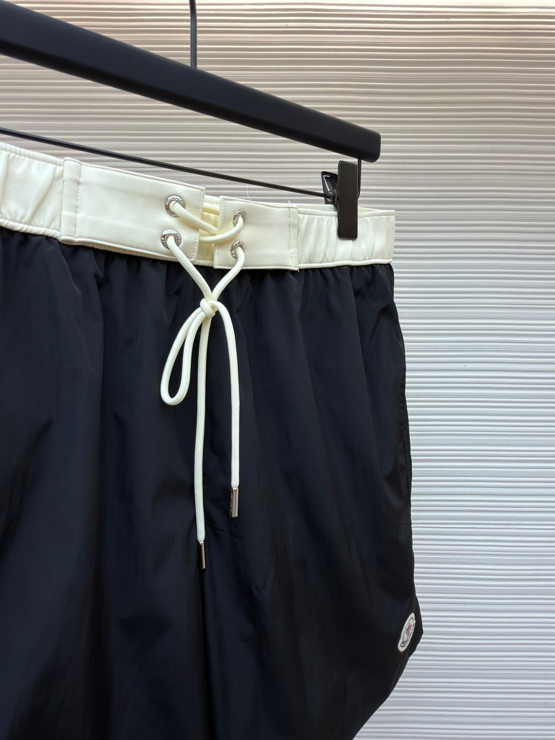 Moncler dark navy swim shorts front view with pale drawstring and loop detail