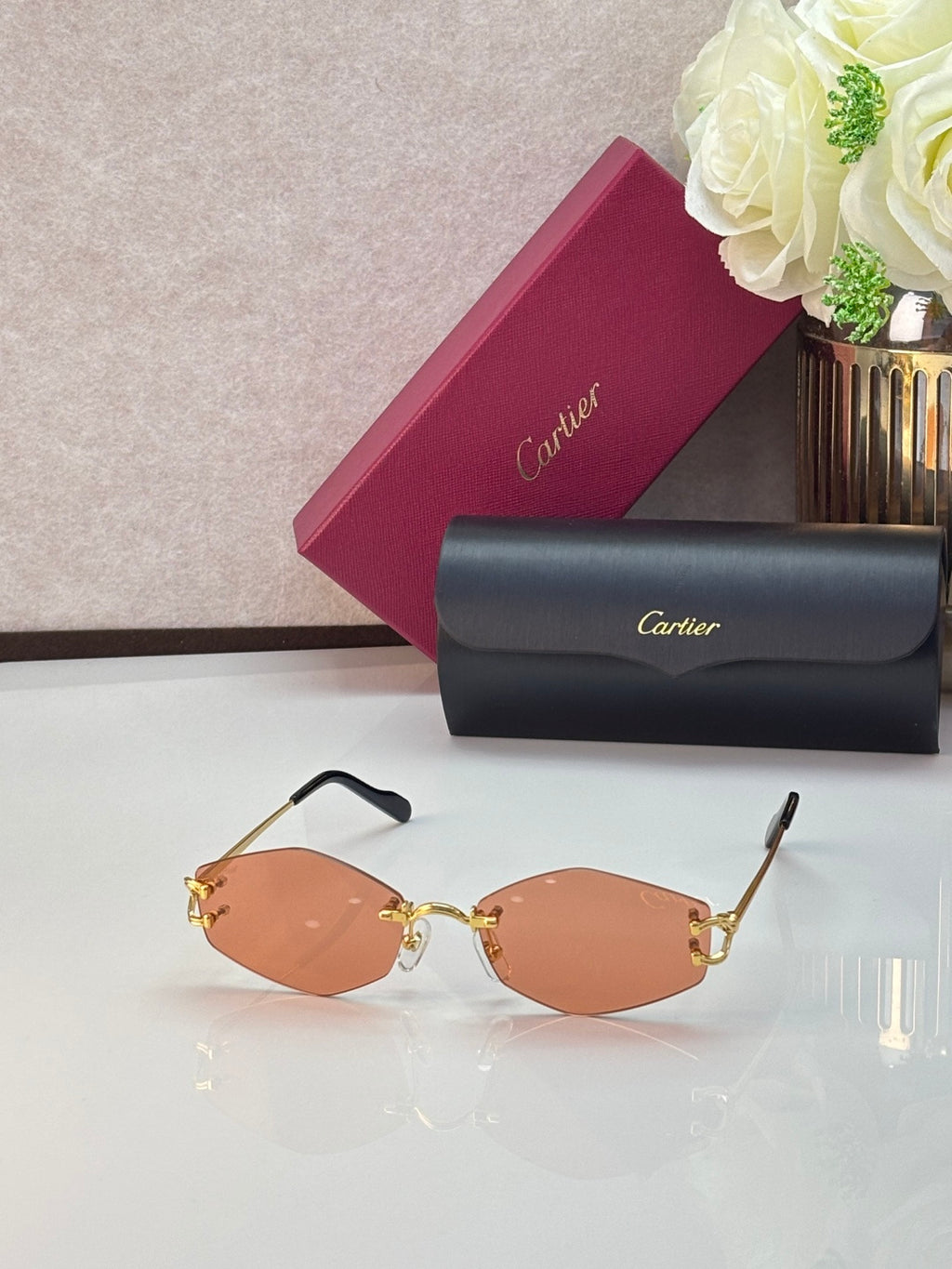 Gold metal sunglasses with orange-tinted lenses and thin gold temple arms
