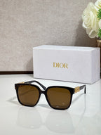 Black sunglasses with gold logo hardware and brown-tinted lenses