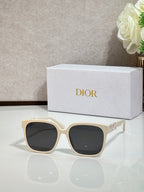 Cream sunglasses with gold logo hardware and dark lenses