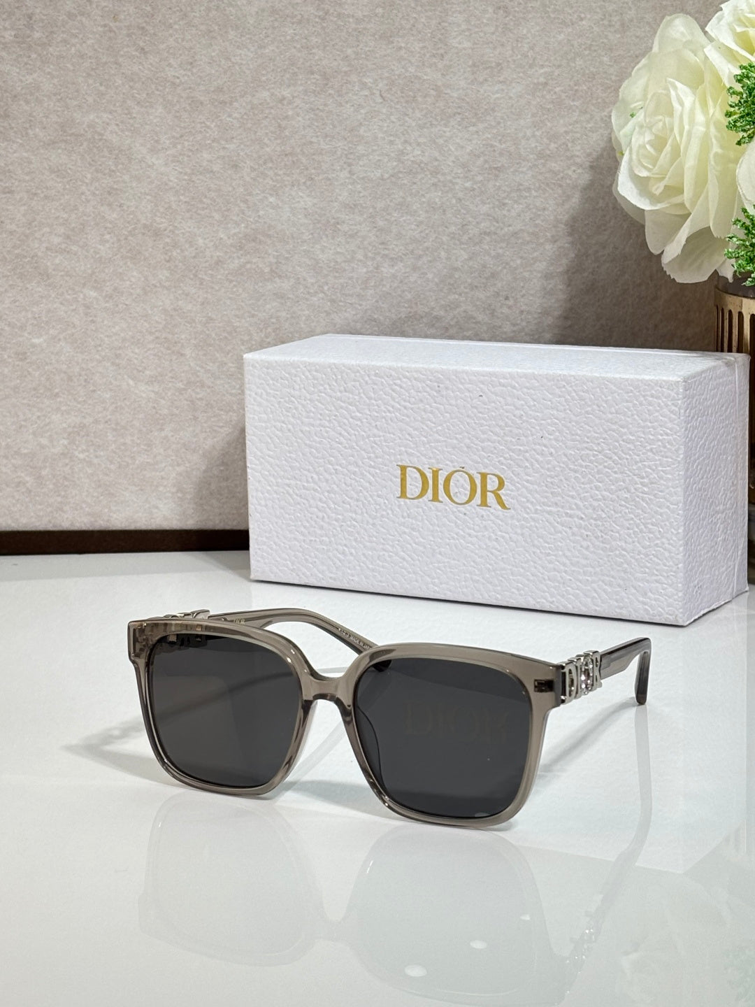 Silver-tone sunglasses with gold logo hardware and dark lenses