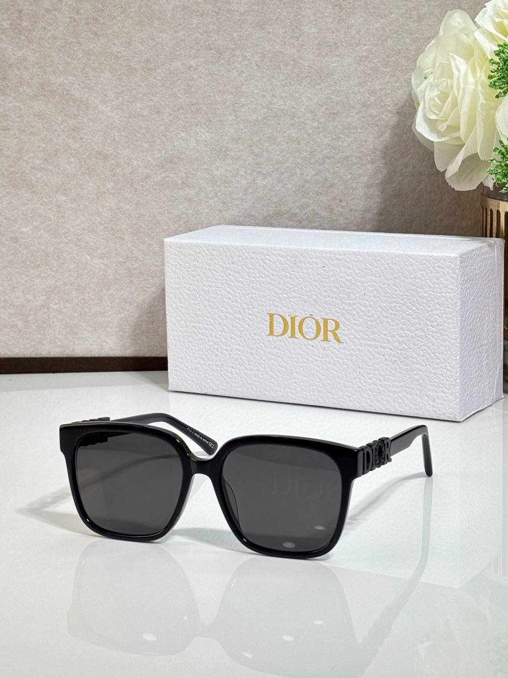 Black sunglasses with gold logo hardware and dark lenses
