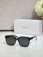 Black sunglasses with gold logo hardware and dark lenses