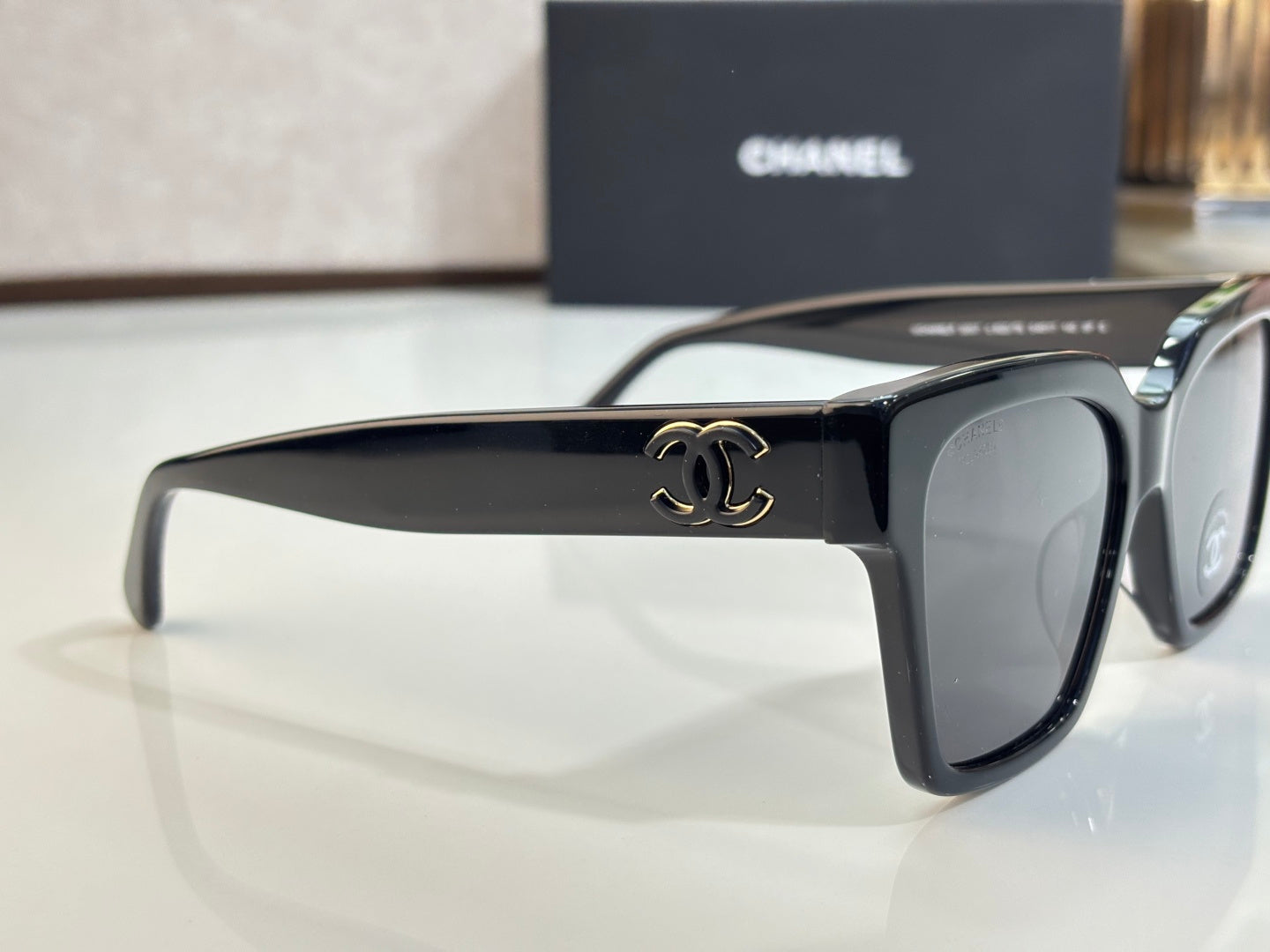 Sunglasses with black frames and gray tinted lenses, temple detail