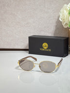 Round sunglasses with clear-smoke lenses, gold-tone frame, and black temple tips