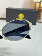 Close-up of round sunglasses with navy lenses and gold-tone metal frame