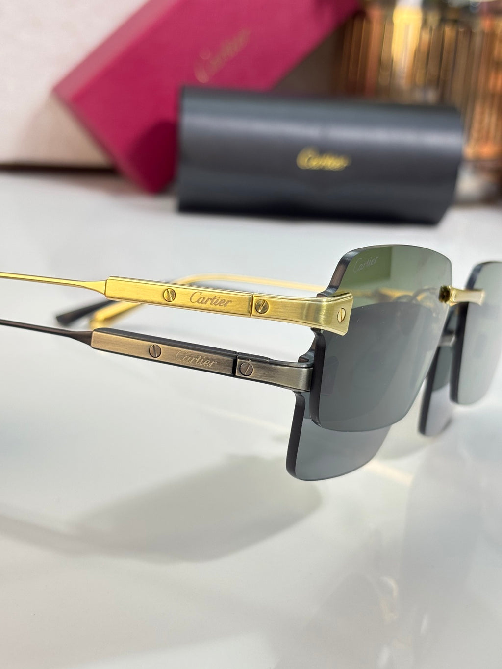 Gold metal sunglasses with green-tinted lens and Cartier logo on temples