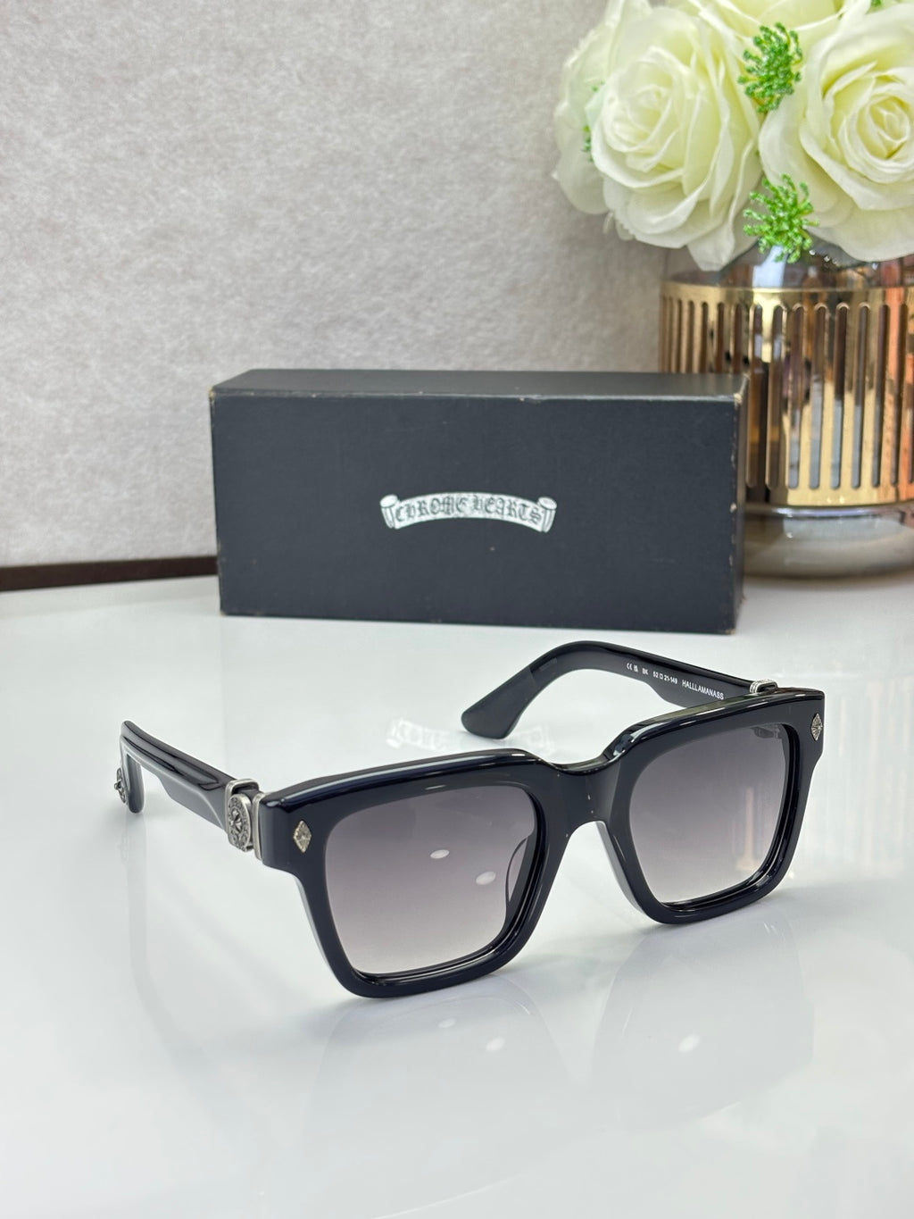 Chrome glasses with black frames and dark lenses, glossy finish