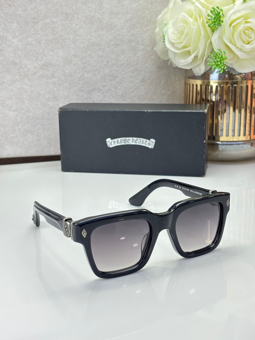 Chrome glasses with black frames and dark lenses, glossy finish