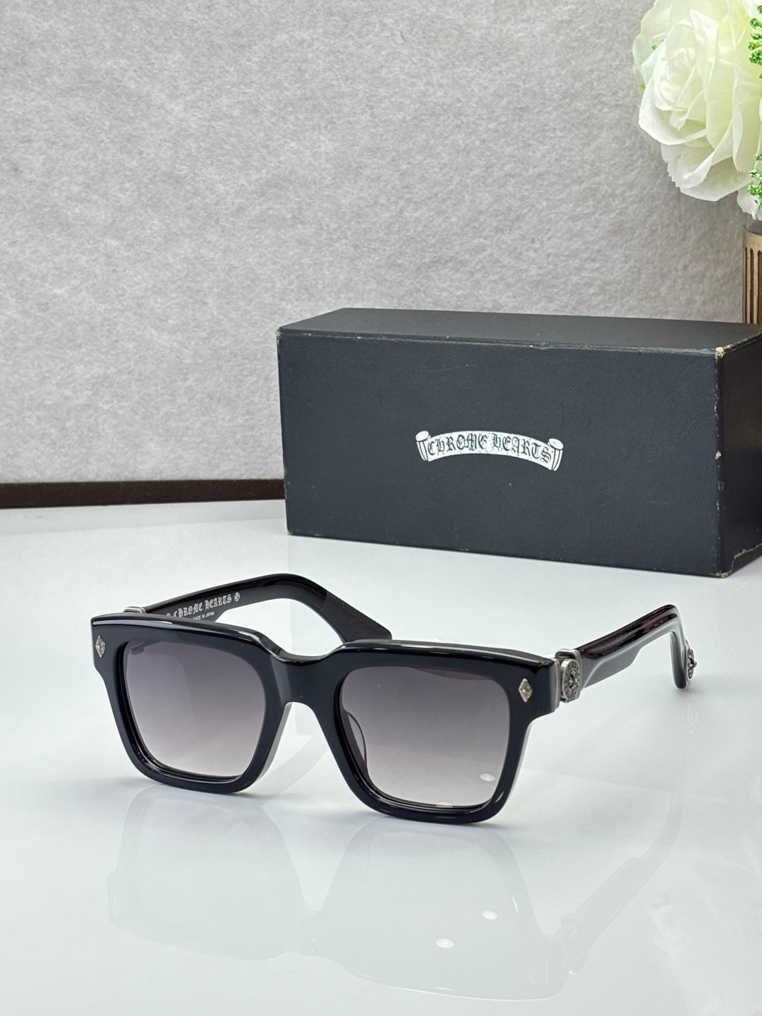 Chrome glasses with black frames and dark lenses, rectangular shape