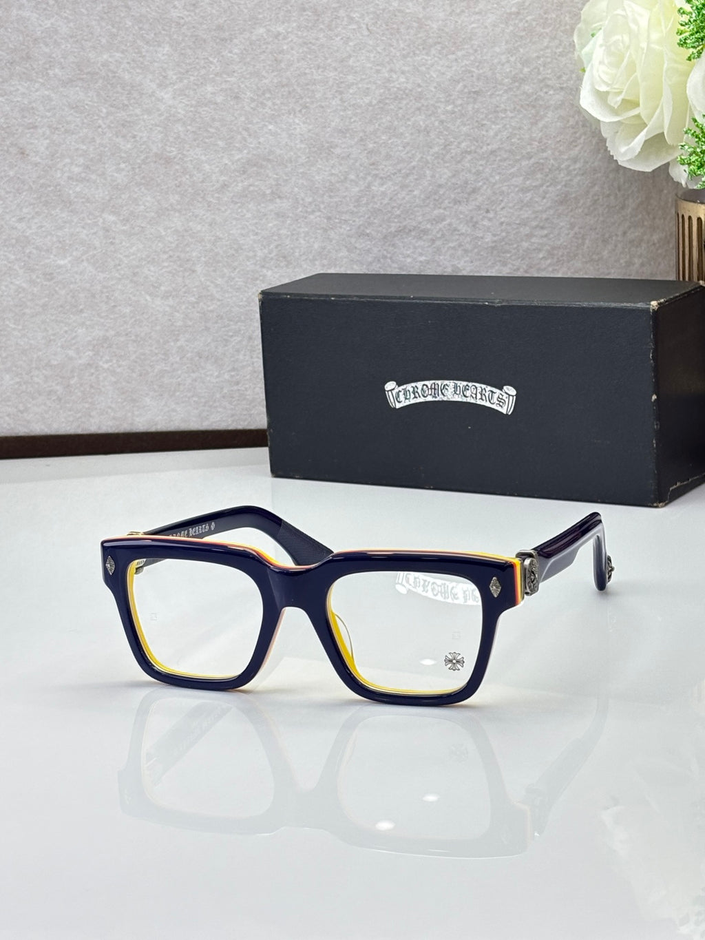 Navy eyeglasses with gold trim, square frames and clear lenses