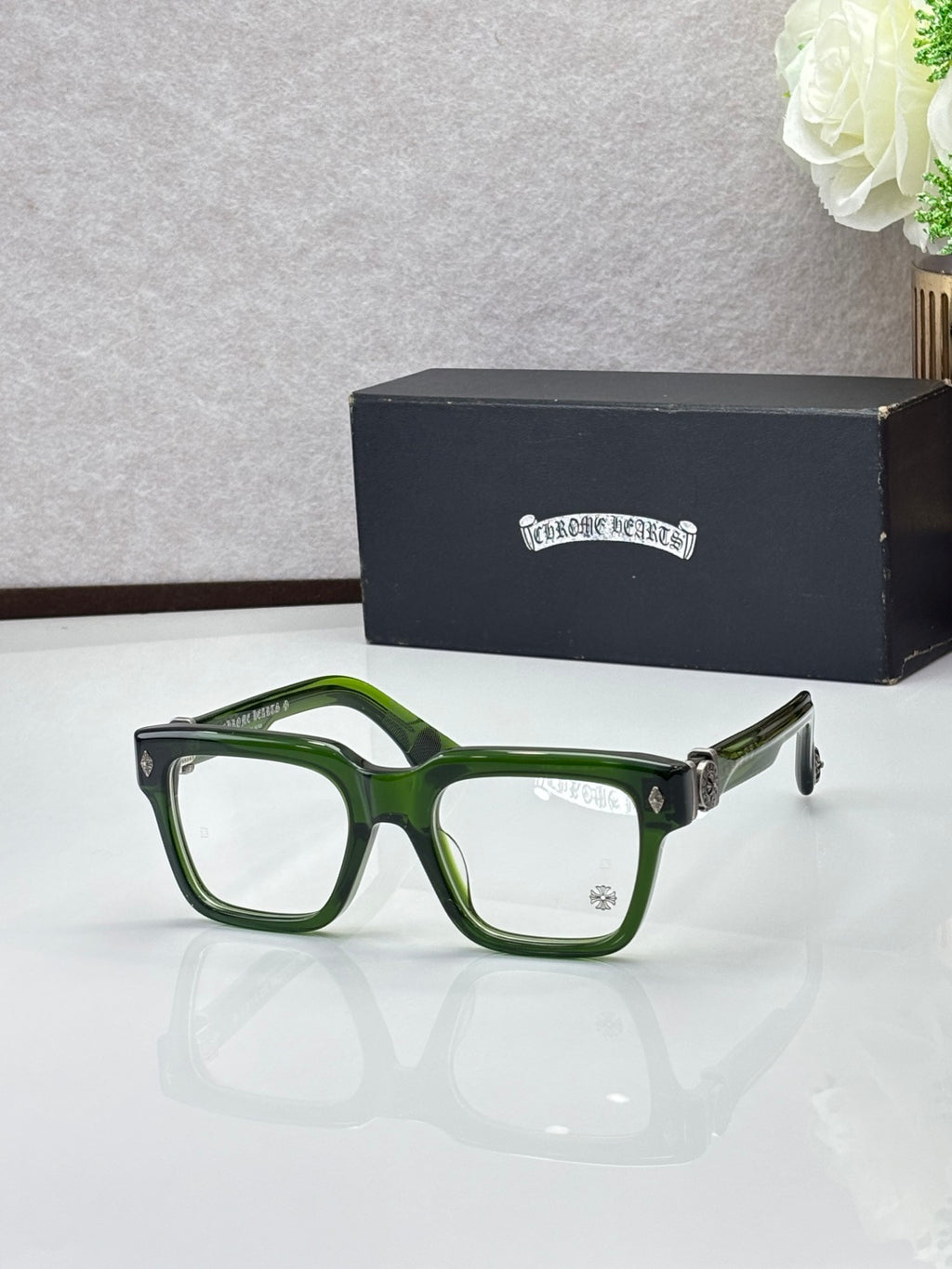 Green eyeglasses with square frames, clear lenses and metal temple hinges