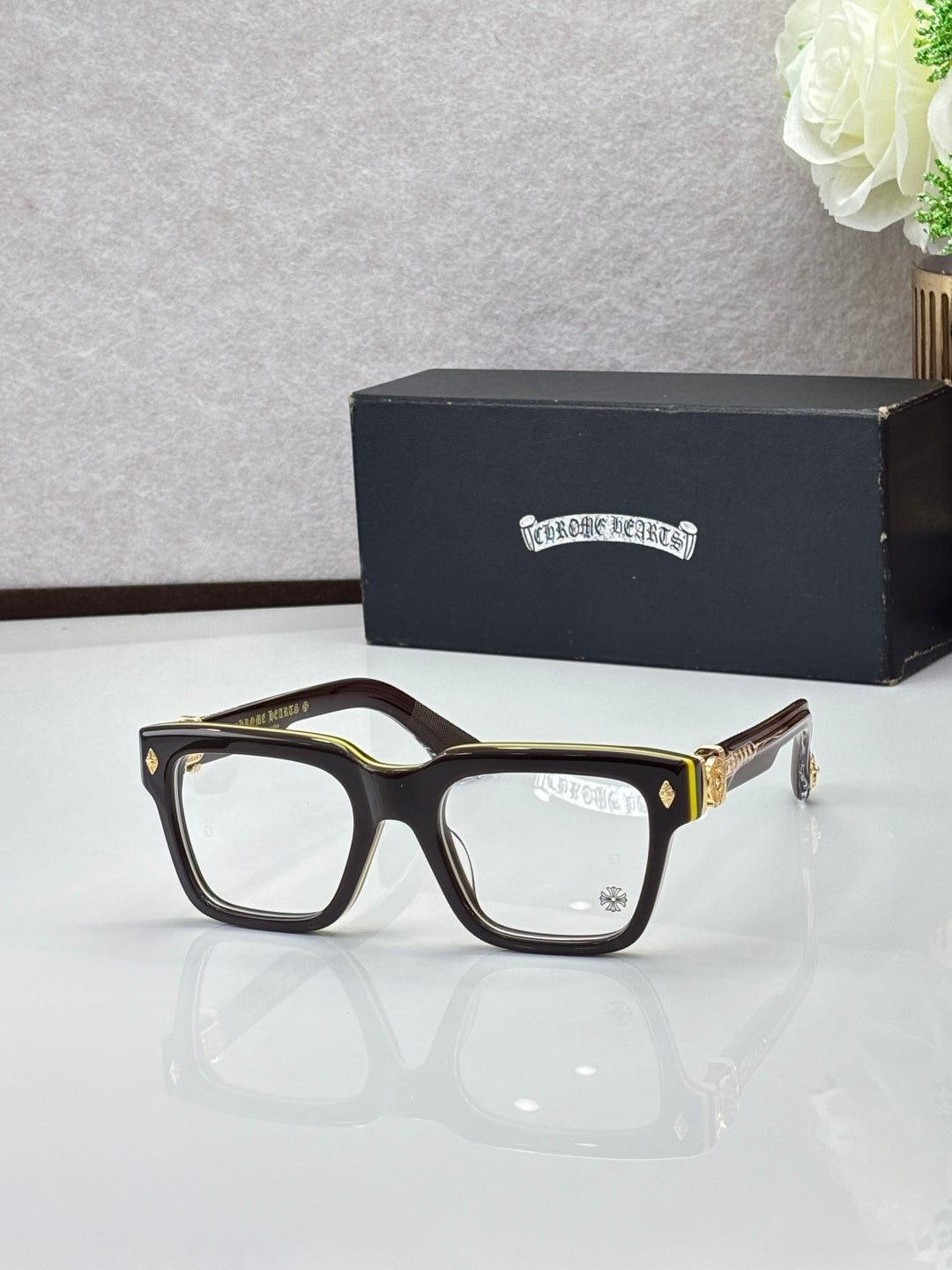 Brown eyeglasses with gold-tone accents, square frames and clear lenses