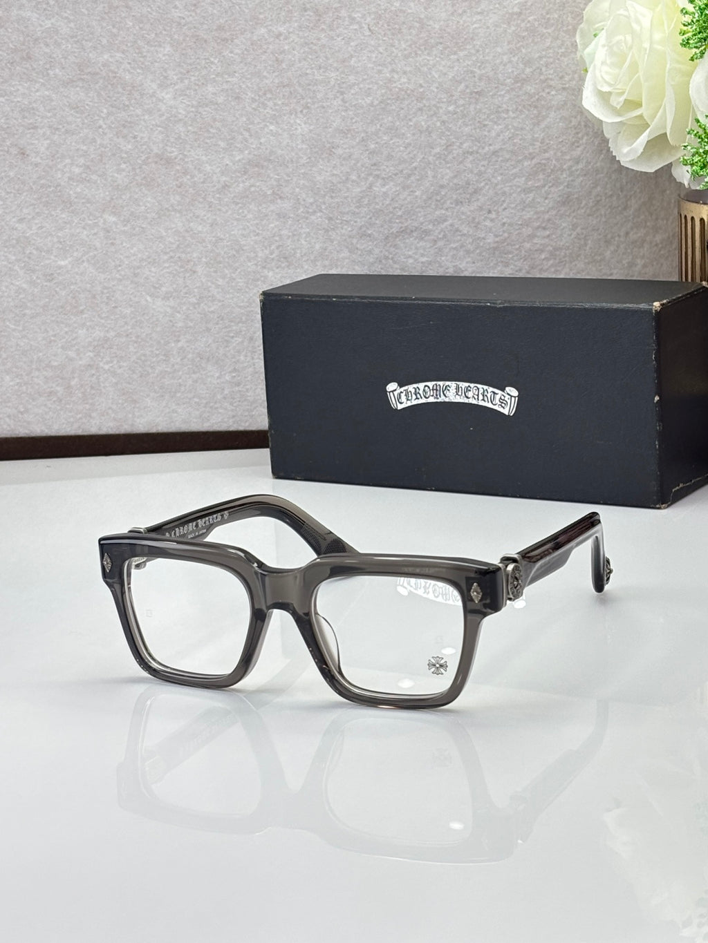 Dark eyeglasses with square frames, gold-tone temple detail and clear lenses