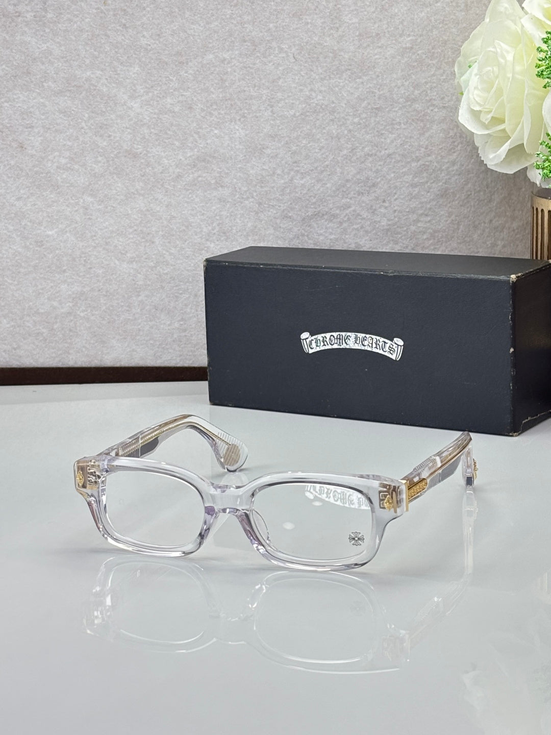Clear frame oval glasses with clear lenses and gold temple accents