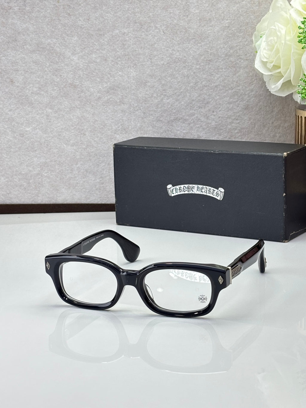 Black oval glasses with clear lenses and gold temple detail