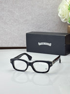 Black oval glasses with clear lenses and gold temple detail