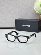 Black oval glasses with clear lenses and gold temple accents