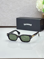 Black oval sunglasses with green-tinted lenses and gold temple detail