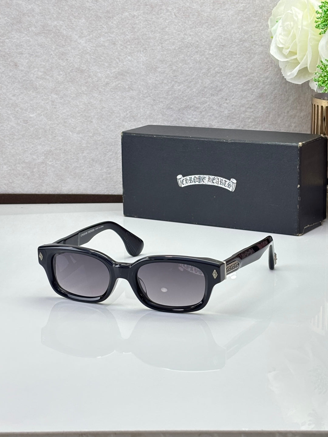 Black oval sunglasses with dark lenses and a gray inner frame