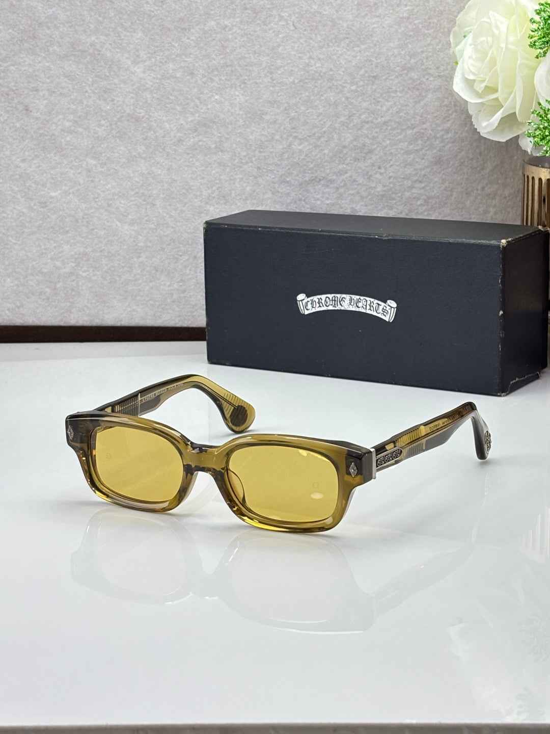 Amber oval sunglasses with yellow lenses and gold-toned temple accents
