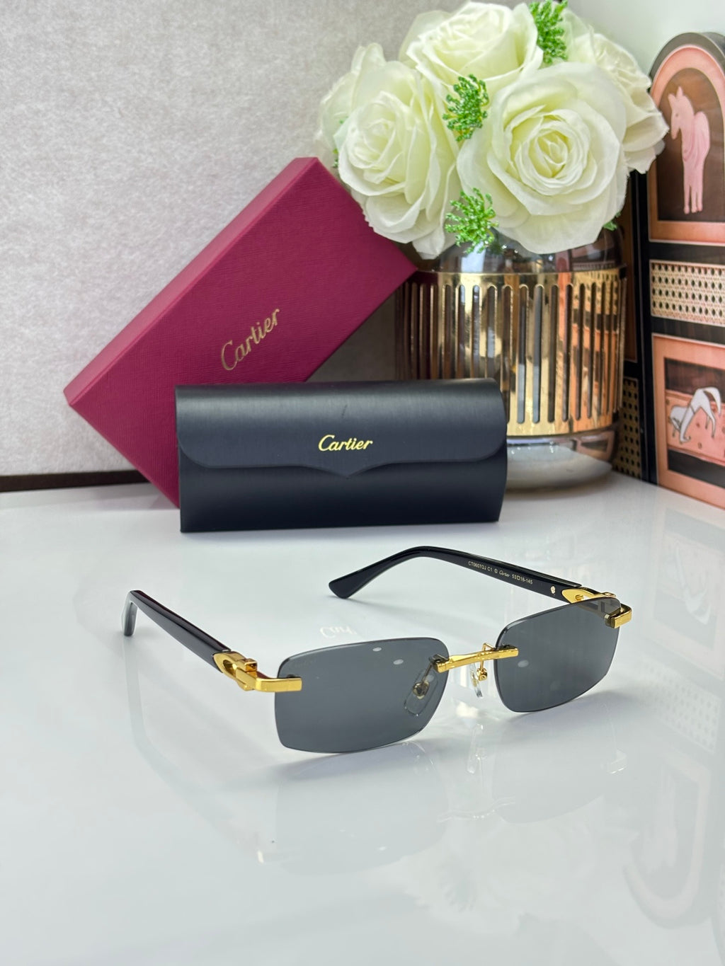 Cartier glasses, black frames with dark gray lenses and gold-tone accents, angled view