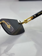 Cartier glasses close-up, dark lens with gold hinge and “Made in” marking on temple