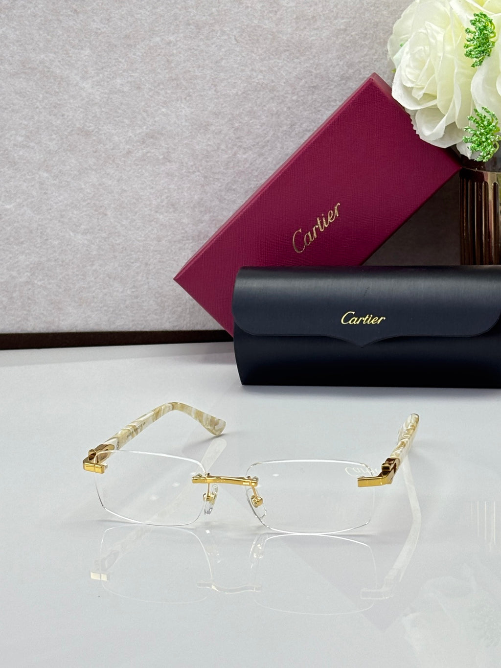 Clear rectangular eyeglasses with gold-tone temples and ornate center bar detail.
