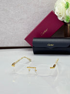 Clear rectangular eyeglasses with gold-tone temples and ornate center bar detail.