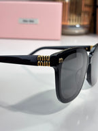 Black sunglasses temple detail with gold Miu Miu logo and dark lens