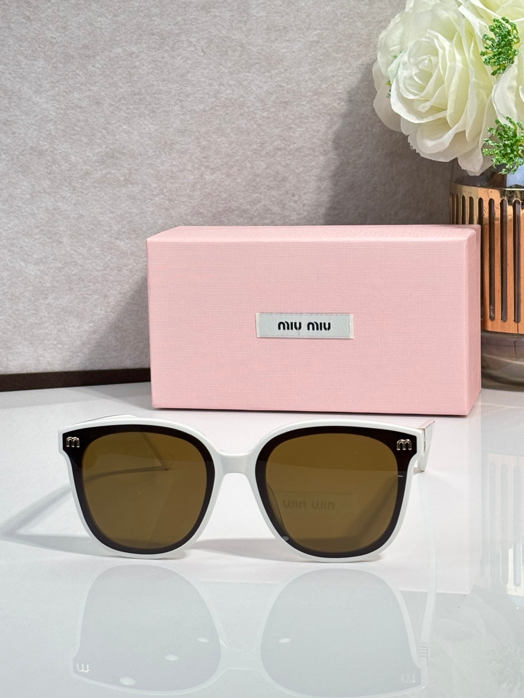White round sunglasses with olive-brown lenses and gold logo on temples