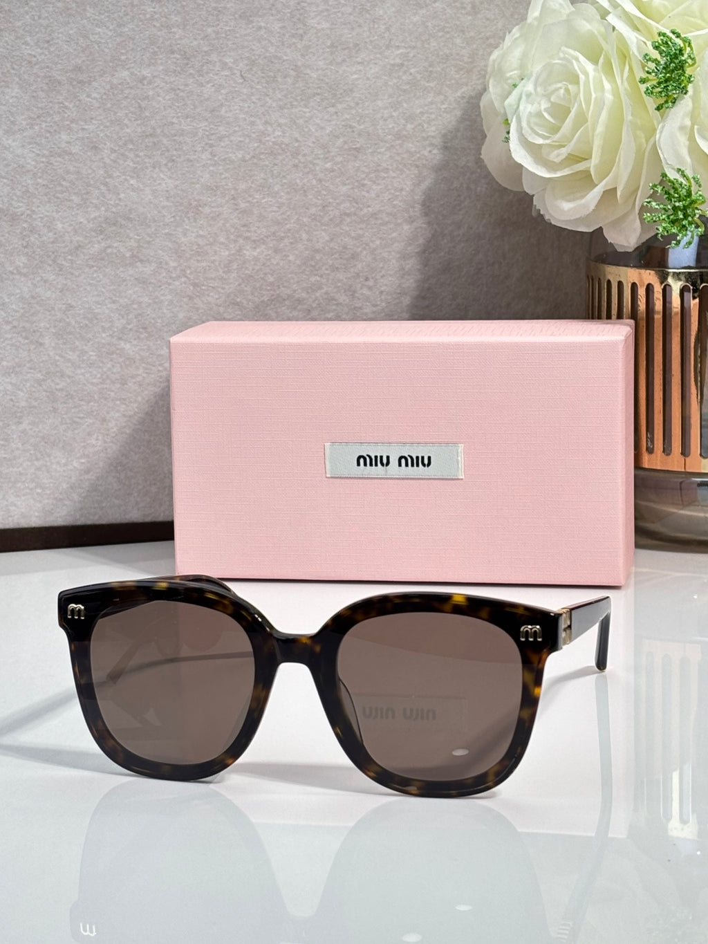 Tortoiseshell round sunglasses with brown-tinted lenses and gold side emblems