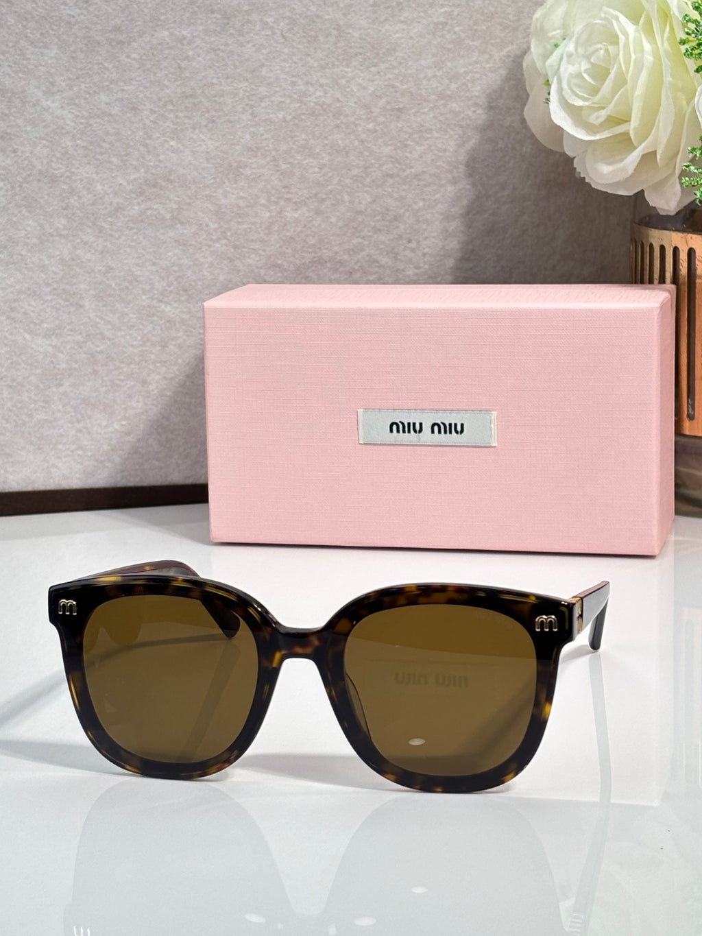 Dark tortoiseshell round sunglasses with olive-brown lenses and gold side emblems