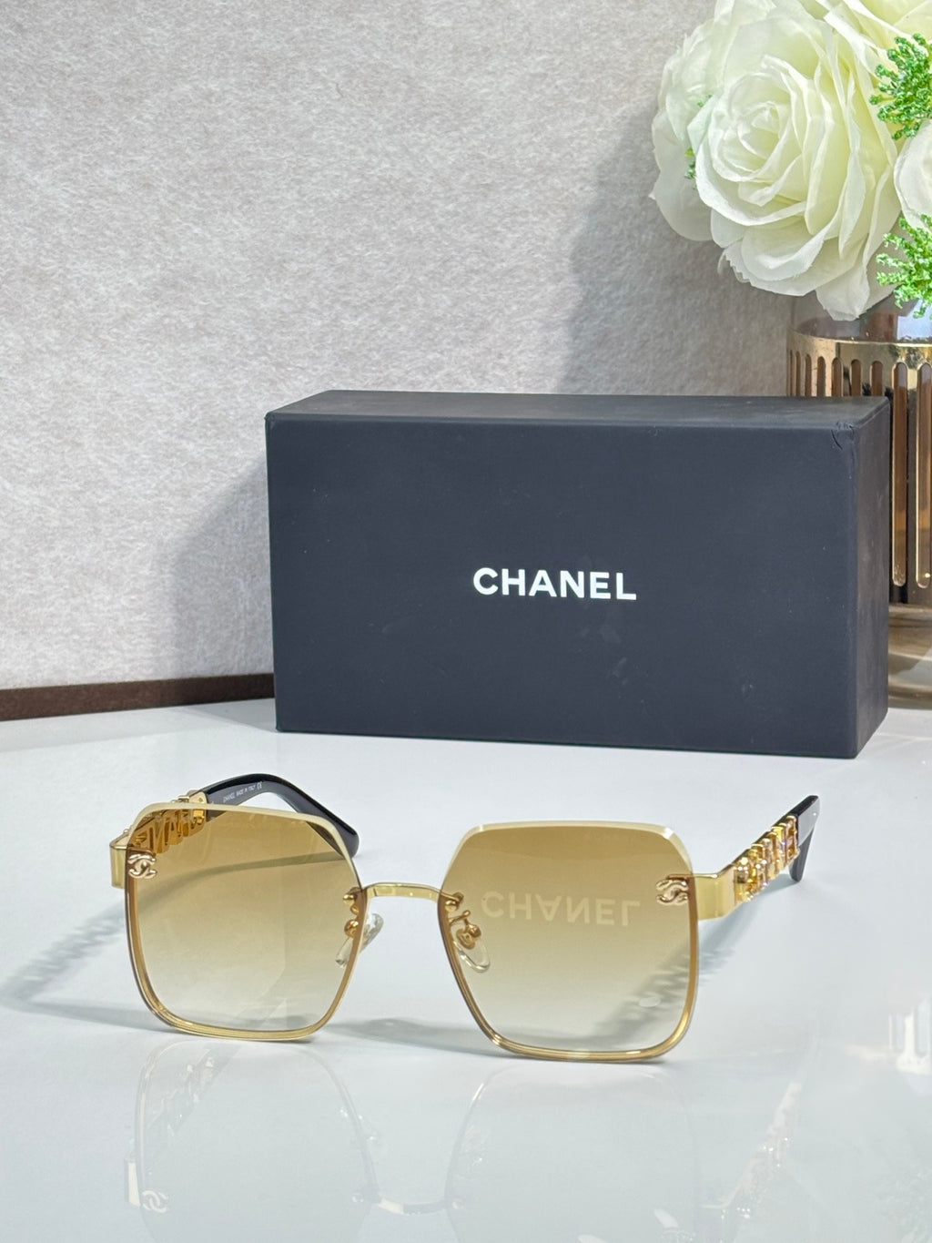 Chanel square sunglasses with light yellow tinted lenses and gold-tone frame