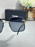 Chanel square sunglasses close-up with dark lenses and gold-tone hardware