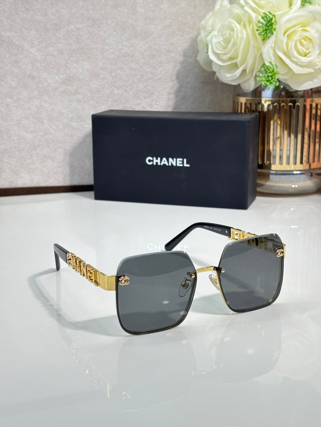 Chanel square sunglasses with dark gray lenses and black frame with gold details