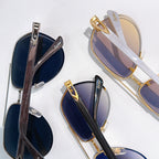 Sunglasses with gold accents and dark blue tinted lenses, overlapping angles