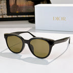 Dior cat-eye sunglasses with black frames and olive-tinted lenses, gold-tone accents