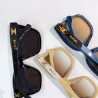Sunglasses laid out: black, blue, and beige frames with tinted lenses