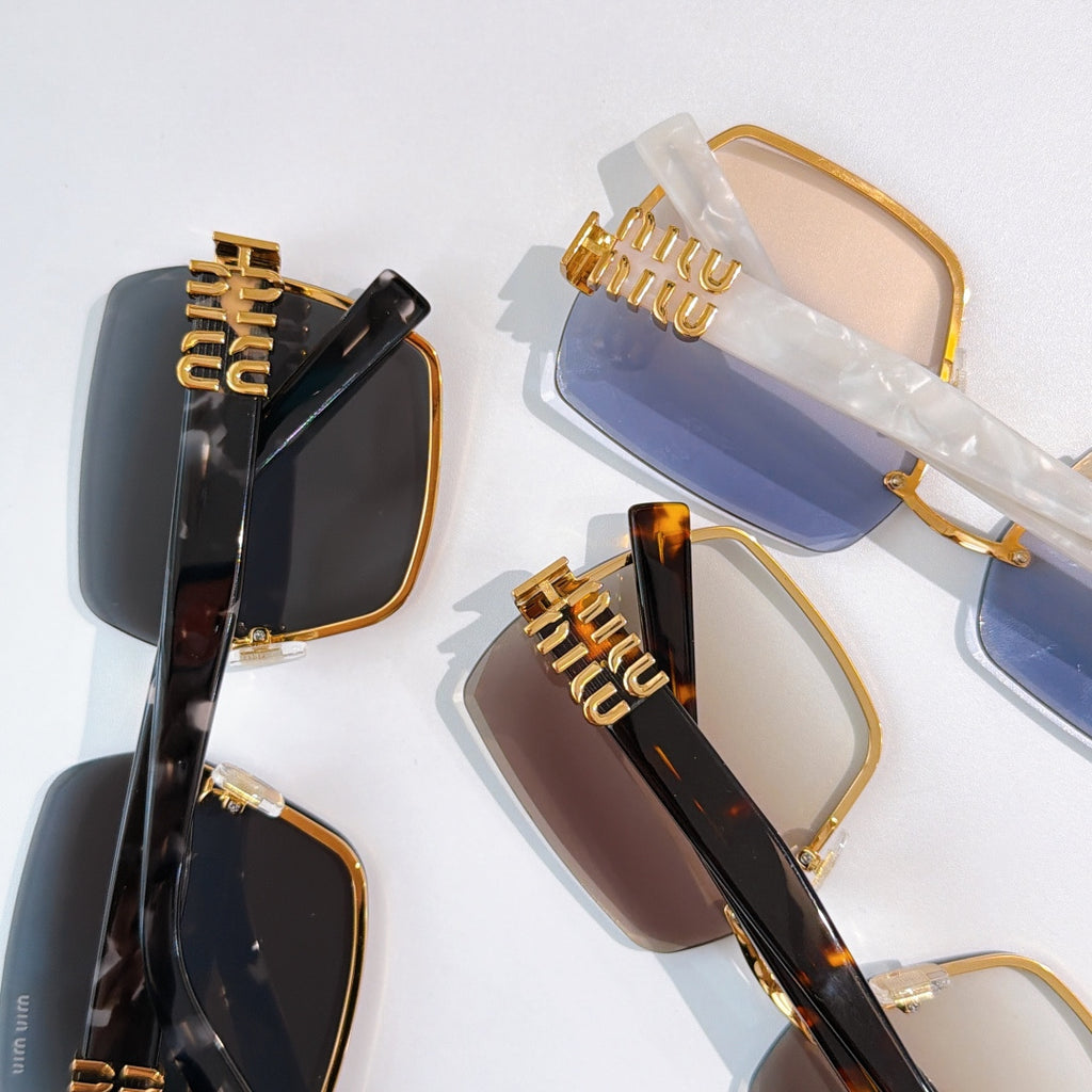 Sunglasses assortment with dark and blue lenses, gold-toned frames, tortoise accents