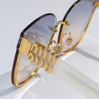 MiuMiu glasses close-up with gold logo hinge and tinted lenses